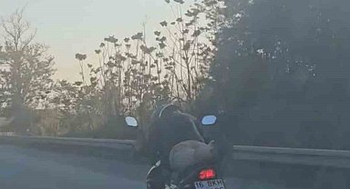 Motosikleti yatarak kullanan sürücü kamerada
