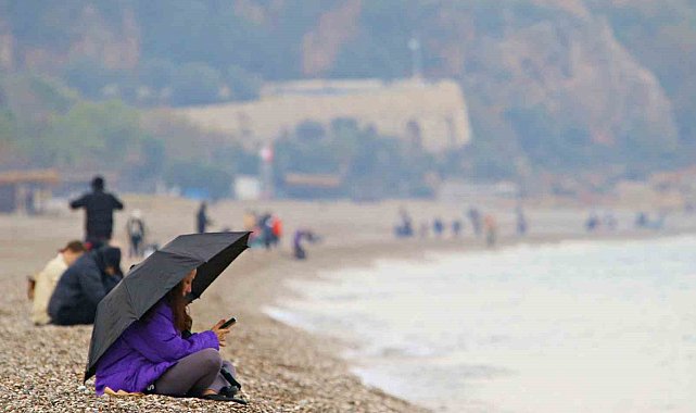 Antalya'da yağmura rağmen şemsiye altında deniz keyfi
