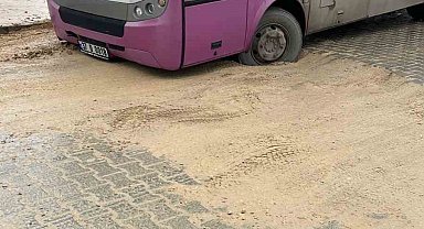 Özel halk otobüsü asfalt atılmayan caddede toprağa battı