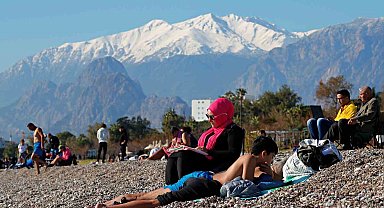Antalya'da karla kaplı dağların gölgesinde deniz ve güneş keyfi
