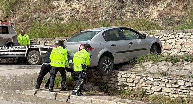 Asılı kalan otomobilini polislerin yardımıyla kurtardı