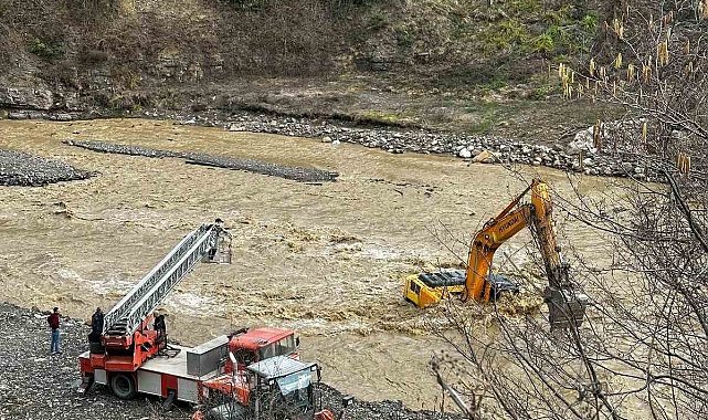 Çayın debisi yükselince iş makinesinin üzerinde mahsur kaldı