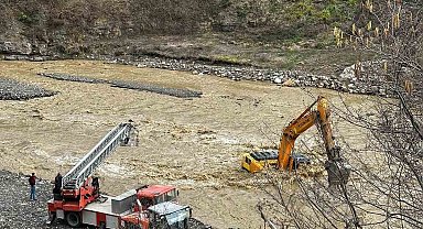 Çayın debisi yükselince iş makinesinin üzerinde mahsur kaldı