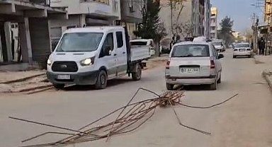 Otomobilin arkasına bağladığı demirlerle trafikte ilerledi