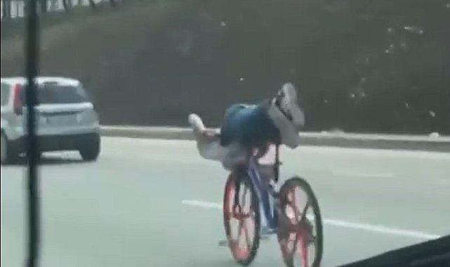 Bisikletin üzerinde uzanarak giden gençler trafiği tehlikeye attı