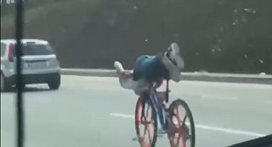 Bisikletin üzerinde uzanarak giden gençler trafiği tehlikeye attı