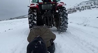 Traktöre bağladıkları lastiklerle kayak keyfi yaptılar