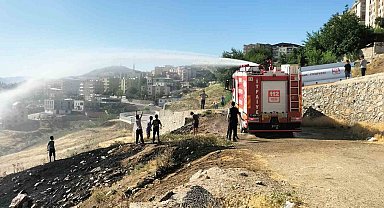İtfaiyeciler yangın söndürme derdinde, çocuklar serinlemenin keyfinde