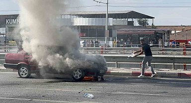 Alev alan otomobilini kendi çabasıyla söndürmeye çalıştı
