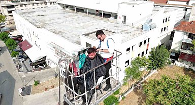 15 yıllık berber yeni açtığı dükkanının ilk tıraşını gökyüzünde yaptı