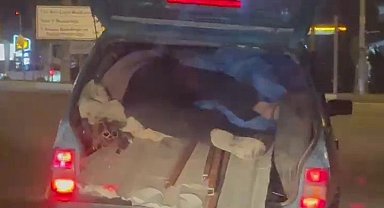 Kapağı açık bagajda yük üzerinde yolculuk yaptı
