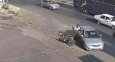 Kazada motosiklet sürücüsü çarpıştığı otomobilin kapısına tutunup sonra yere düştü