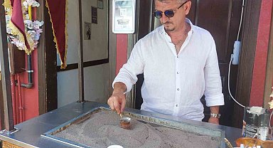 Kızgın kumda kahveyi faklı aromalarla sunuyor