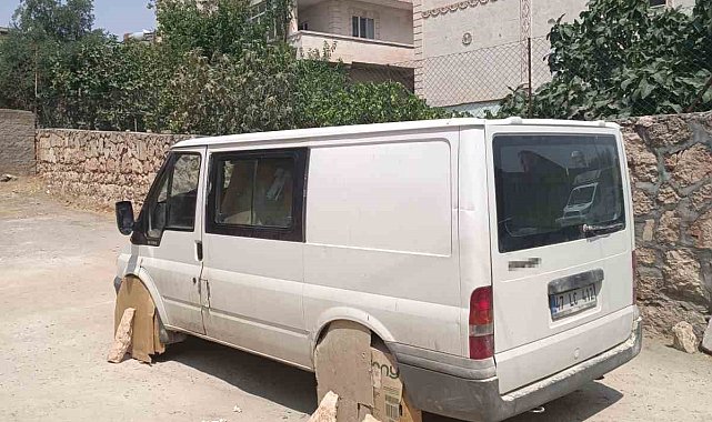 Mardin'de minibüs sürücüsü, aracın tekerlerini sıcaktan korumak için kartonla kapattı