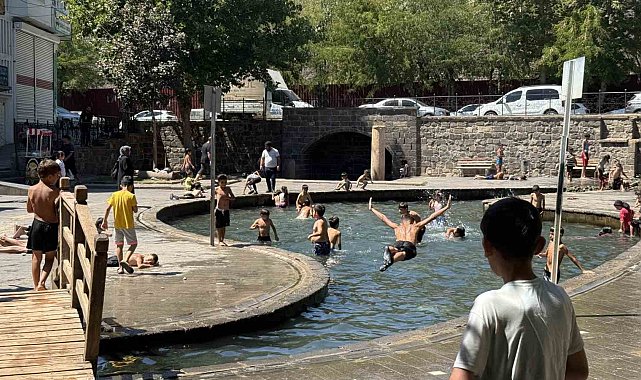 Sıcak havada kavrulan çocuklar, süs havuzunda serinliyor