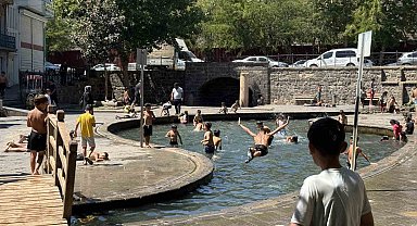 Sıcak havada kavrulan çocuklar, süs havuzunda serinliyor