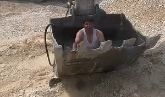 Sıcaktan bunalan işçiler kepçeyi havuza çevirdi