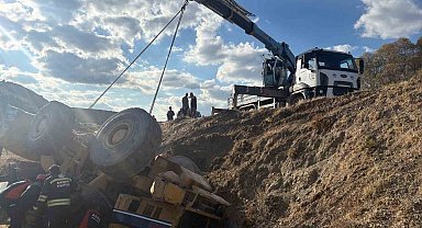 Devrilen iş makinesi altında kalan operatör kurtarıldı