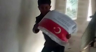 Kendi ağırlığı kadar un çuvalını taşıyan Filistinli çocuğun sevinci