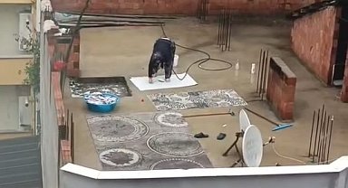 Yağmurlu havada çatıda halı yıkadı, görenler şaştı kaldı