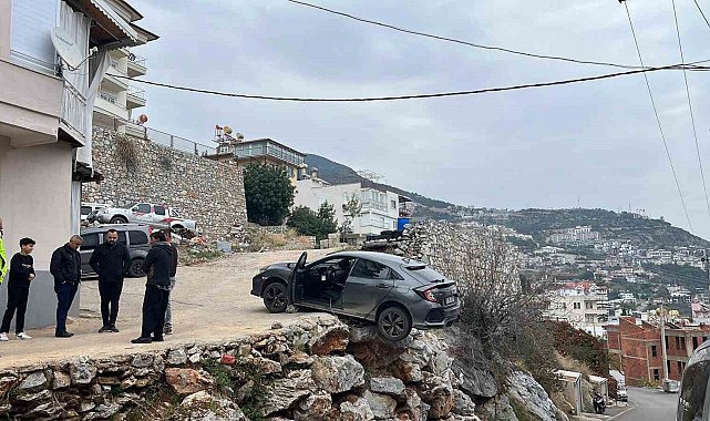 Antalya'da geri manevra yapan araç şarampolde asılı kaldı