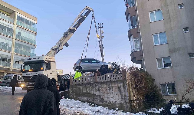 Buzlanan yolda kayan otomobil apartmanın bahçesine düştü