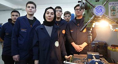 Kadın öğretmen torna tezgahında öğrencilerine üretimi öğretiyor