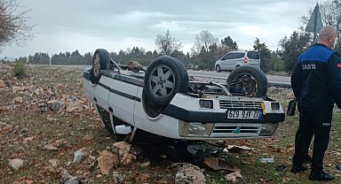 Araziye devrilen otomobilden yara almadan çıktılar