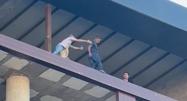 Binanın en üst katında intihara kalkışan şahsı son anda kurtardı: O anlar kamerada