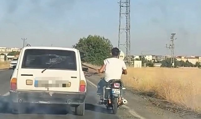 Otoyolda tehlikeli yolculuk: Motosiklet, otomobil kemerine tutunarak ilerledi
