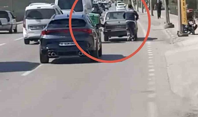 Bursa'da motokuryeden arızalanan otomobili itmek için ilginç yöntem