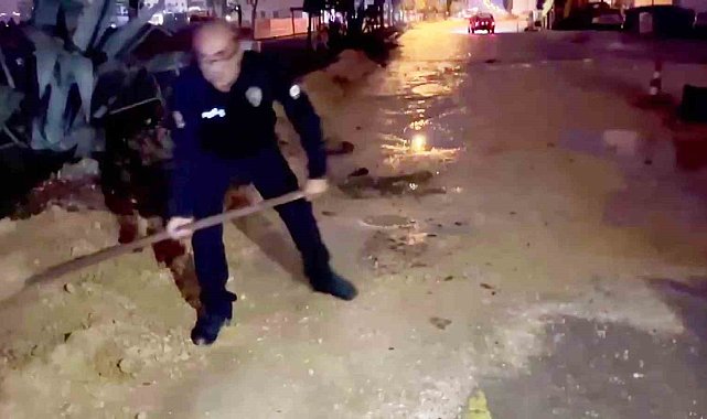 Araçlar zarar görmesin diye küreği eline alan polis memurları, suyla dolan çukurları toprakla doldurdular