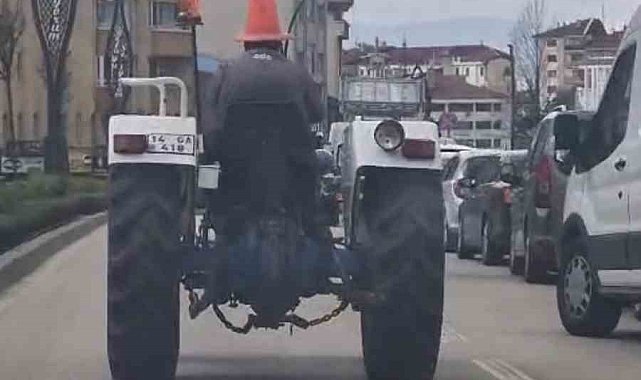 Bolu'da trafikte ilginç görüntü: Başına duba geçirip traktör sürdü