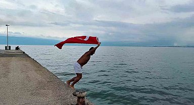 Soğuk ve yağışlı havaya aldırmadı, Türk bayrağıyla denize girdi