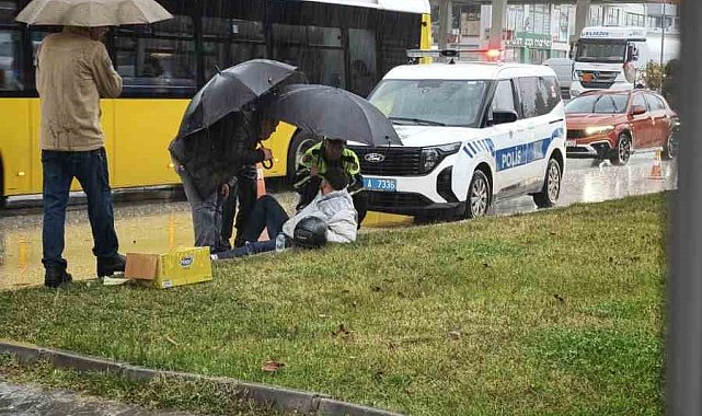 Yağmur altında ıslanan yaralıya trafik polisi şemsiye tuttu